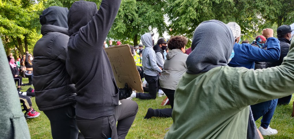 Protesters taking a knee on the grass and hold their fists up in a show of solidarity among residents of Leicester and others who came to support BLM